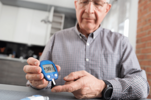 Senior man checking his blood sugar level with a glucose monitor, highlighting early signs of diabetes in men